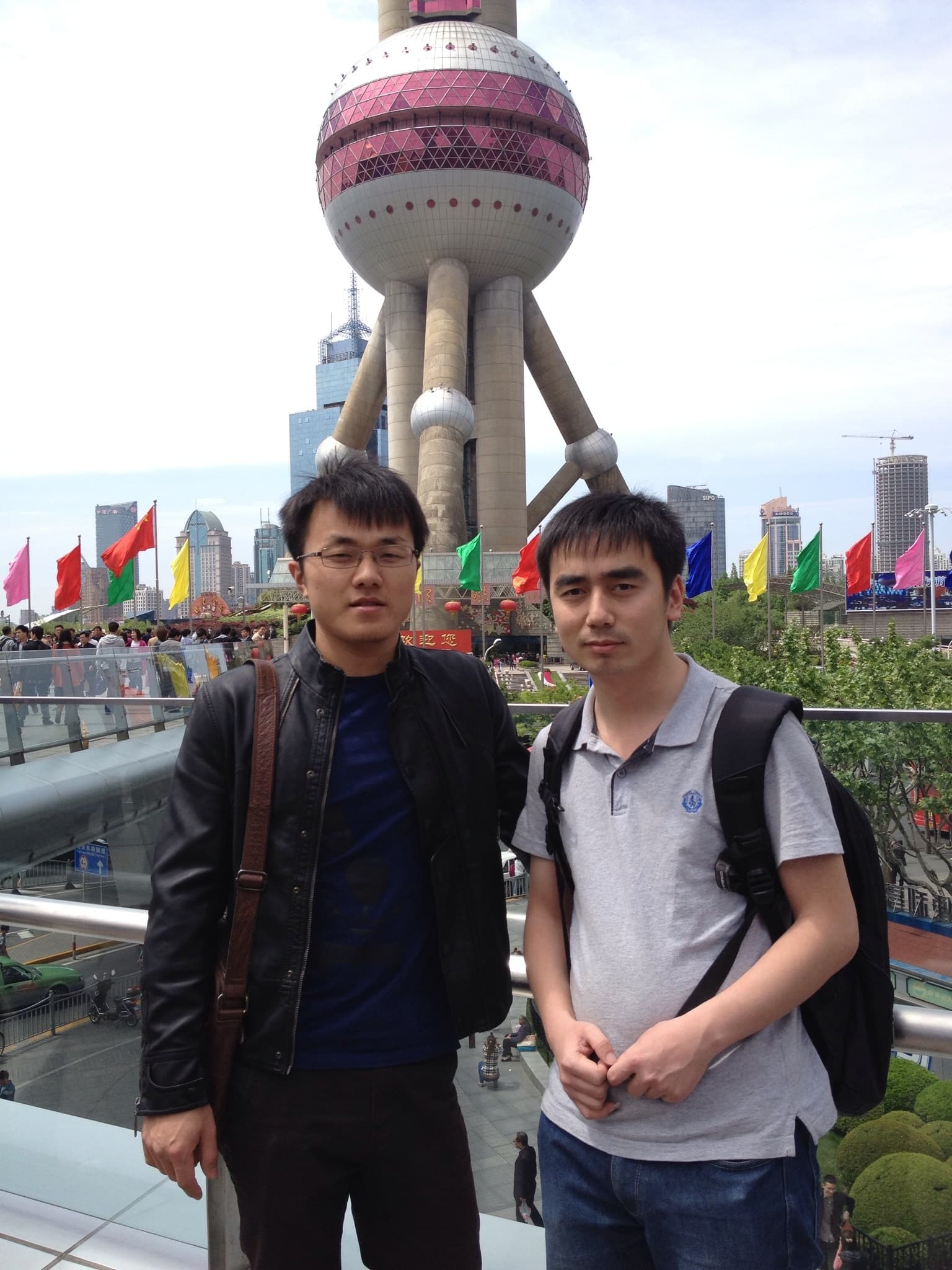 Two men standing in front of Oriental Pearl Tower in Shanghai