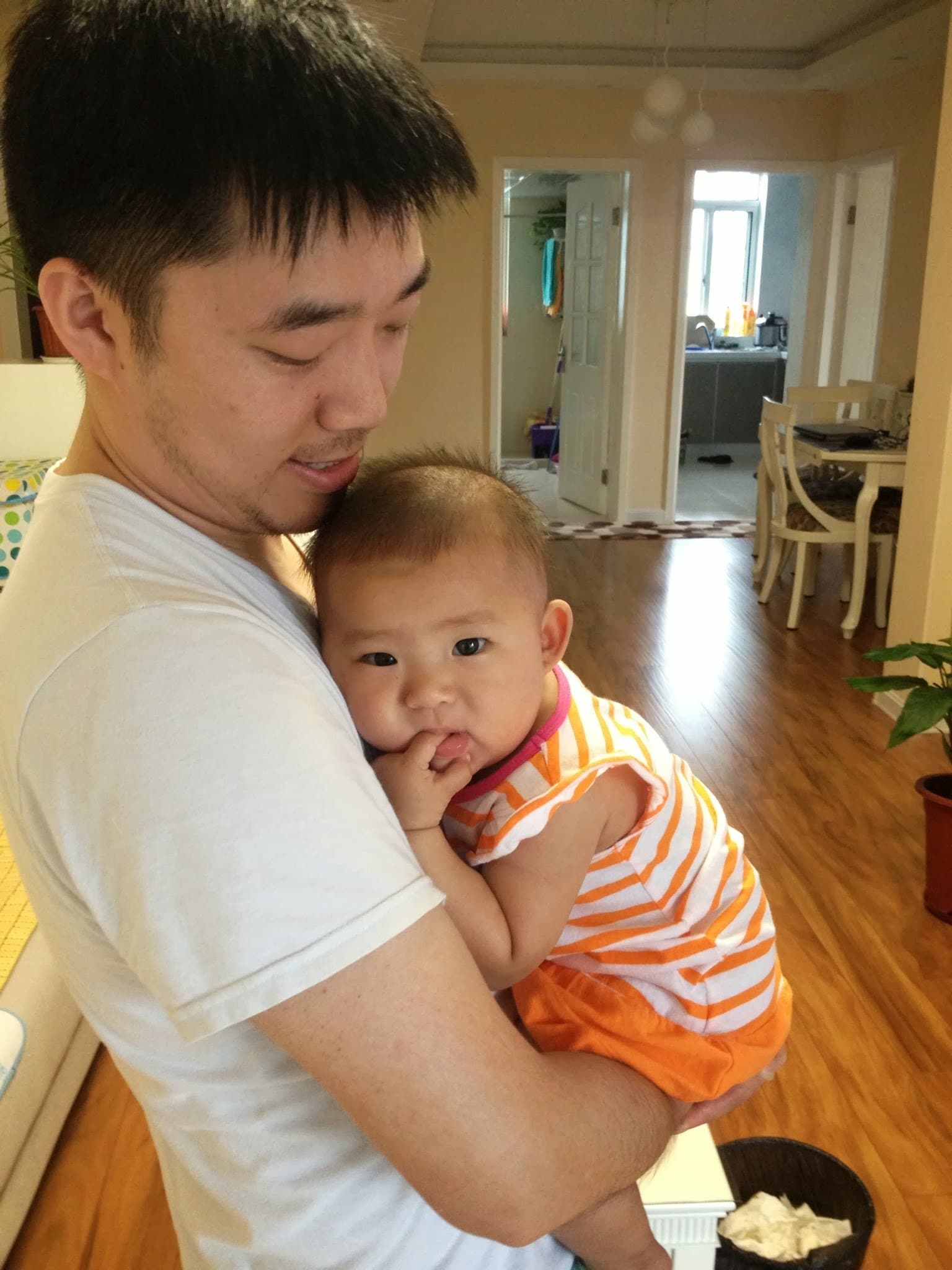 Man holding baby in a domestic setting