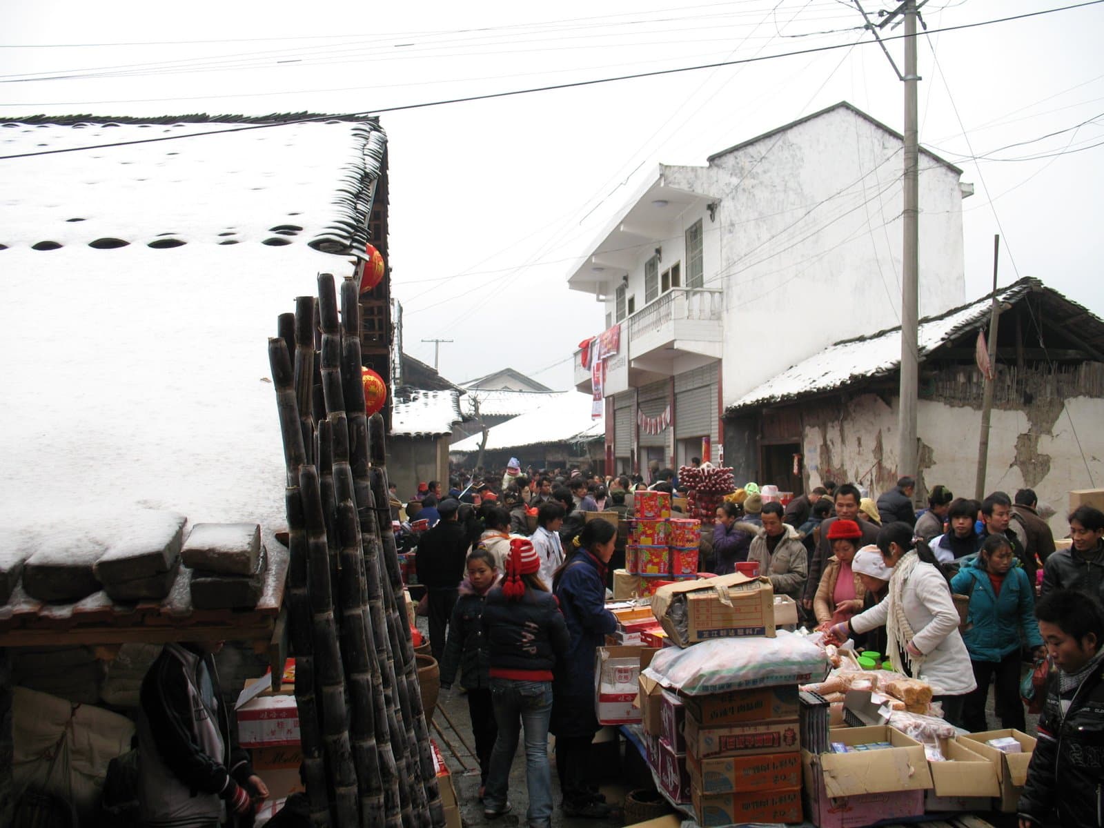Crowd of people shopping at outdoor market stalls