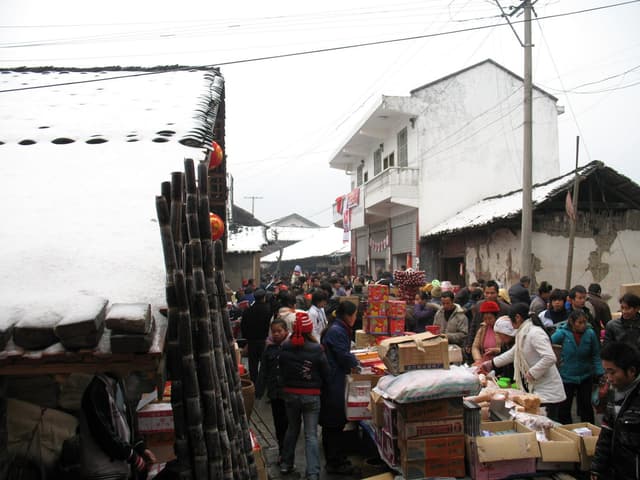 Crowd of people shopping at outdoor market stalls