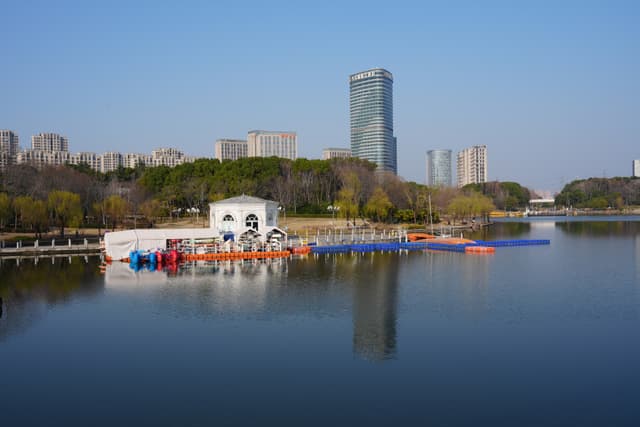 A city skyline along a lake with a dock and boats