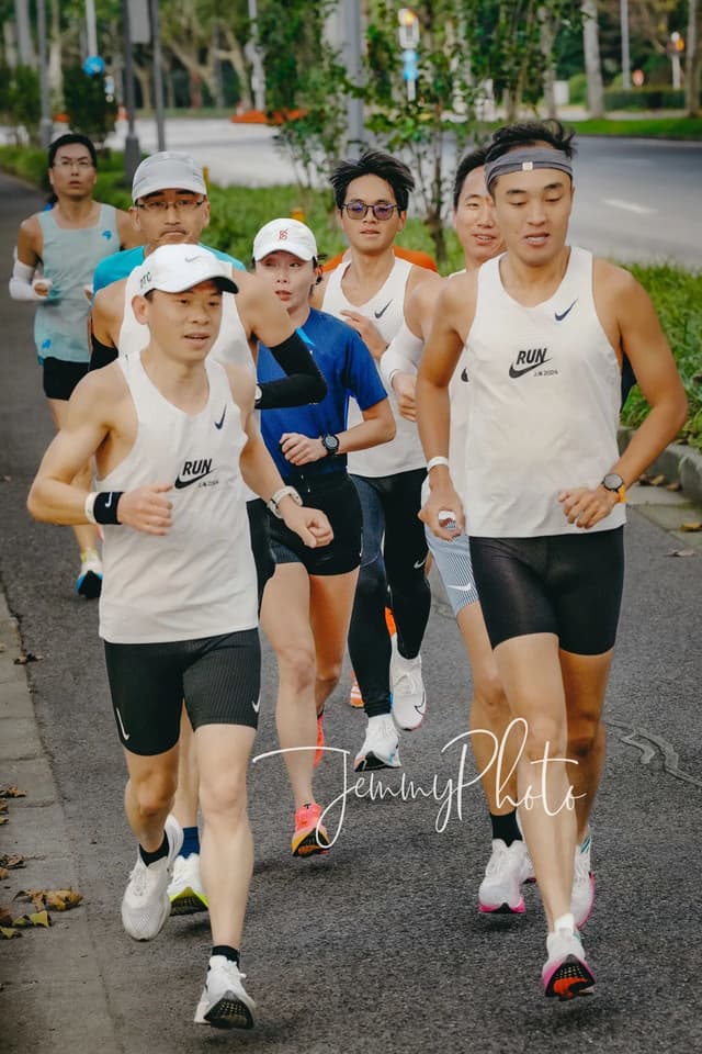 Group of people jogging on a paved road
