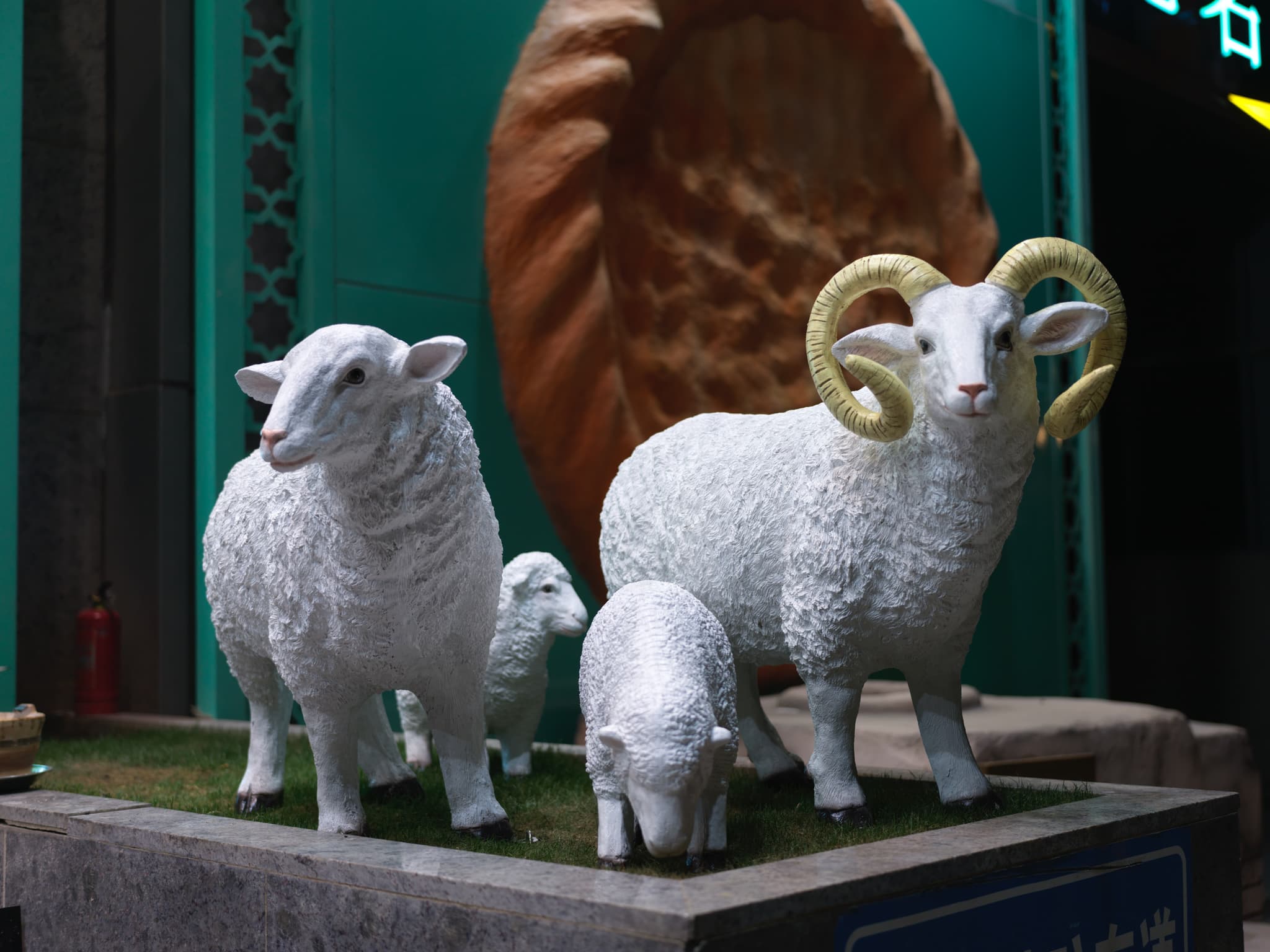 Three white sheep statues on a platform