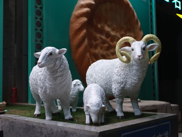Three white sheep statues on a platform