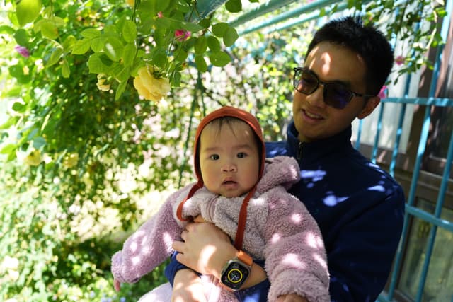 A man holding a baby outside