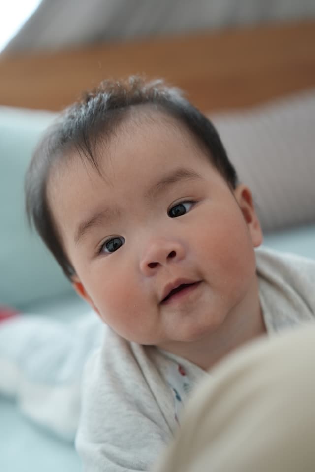 A close-up of a baby's face with a curious expression