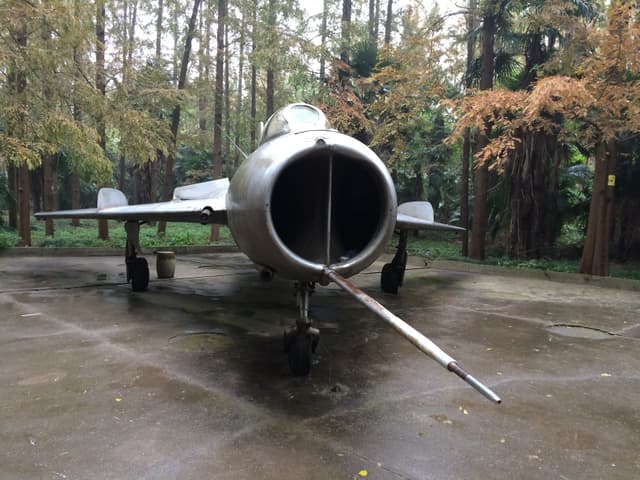 Close-up of an aircraft engine with trees in the background