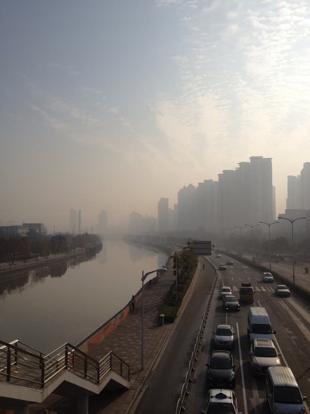 A foggy cityscape with buildings and a body of water