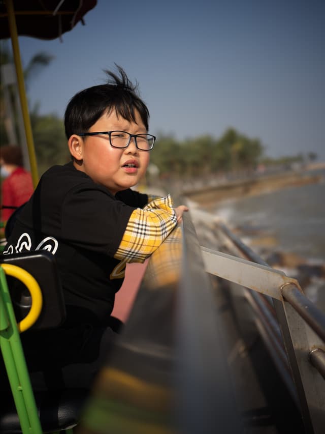 a woman with dark hair and glasses looking over a railing