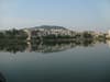 A cityscape with buildings reflected in a calm lake