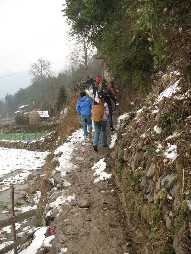 People hiking on a snowy mountain trail