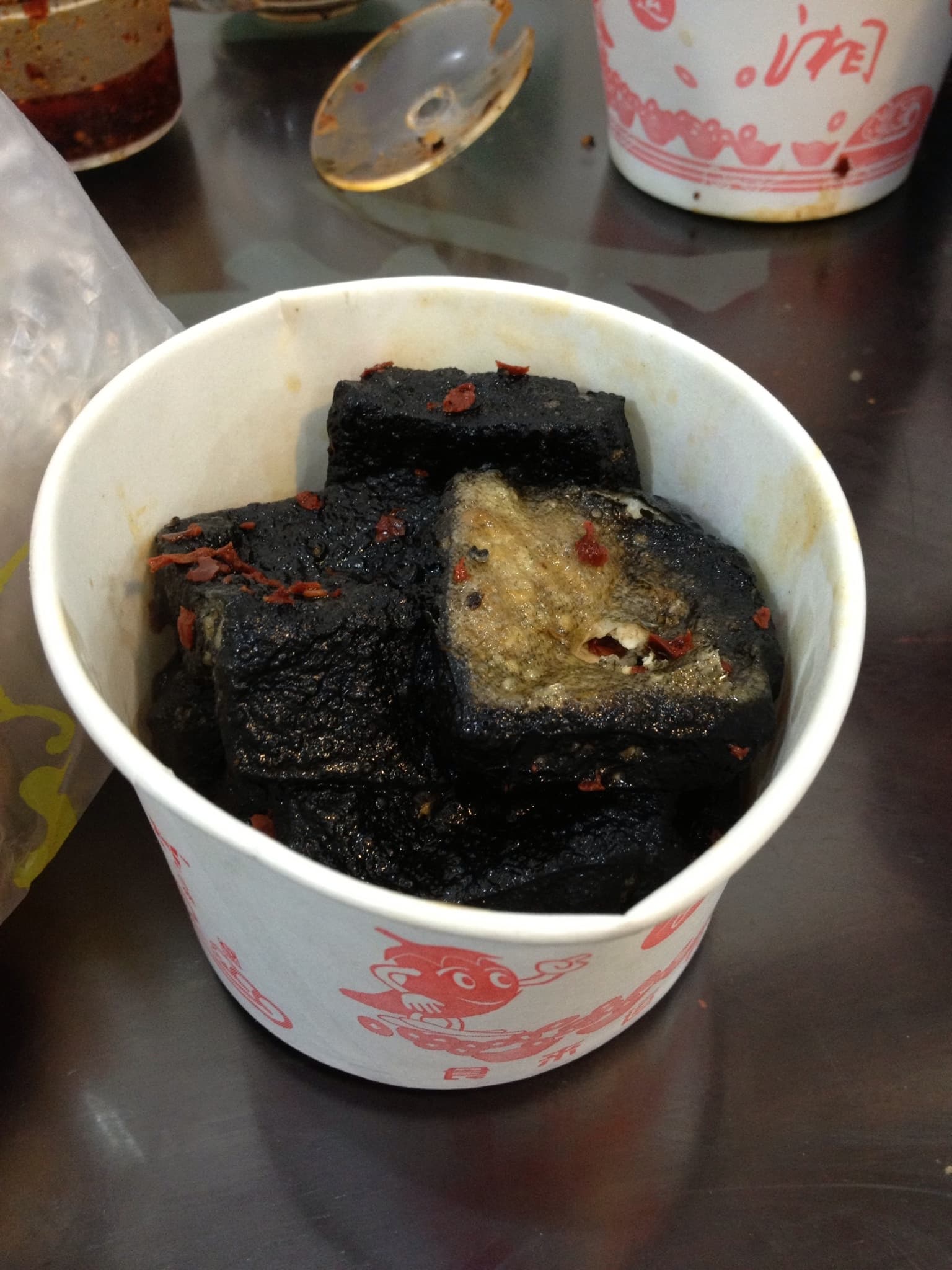 A paper cup containing Changsha Stinky Tofu